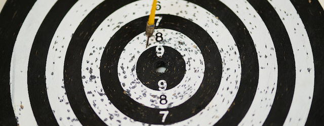 Schwarz-weiße Dartscheibe mit einem Pfeil in der Mitte