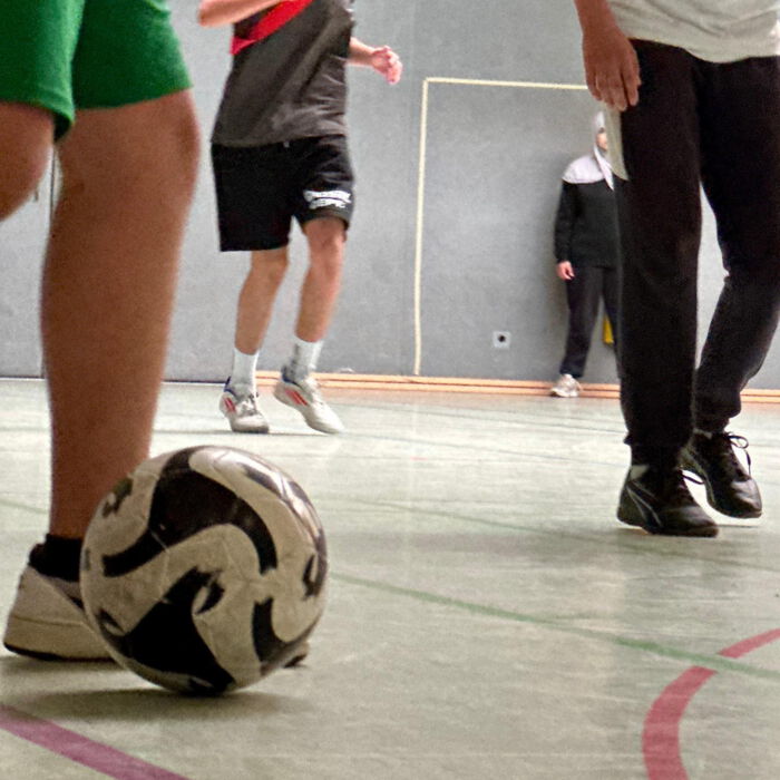 Nahaufnahme eines Fußballs am Fuß eines Spielers in der Sporthalle