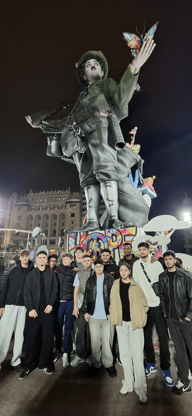 Jugendliche vor einer großen Fallas Figur bei Nacht in Valencia.