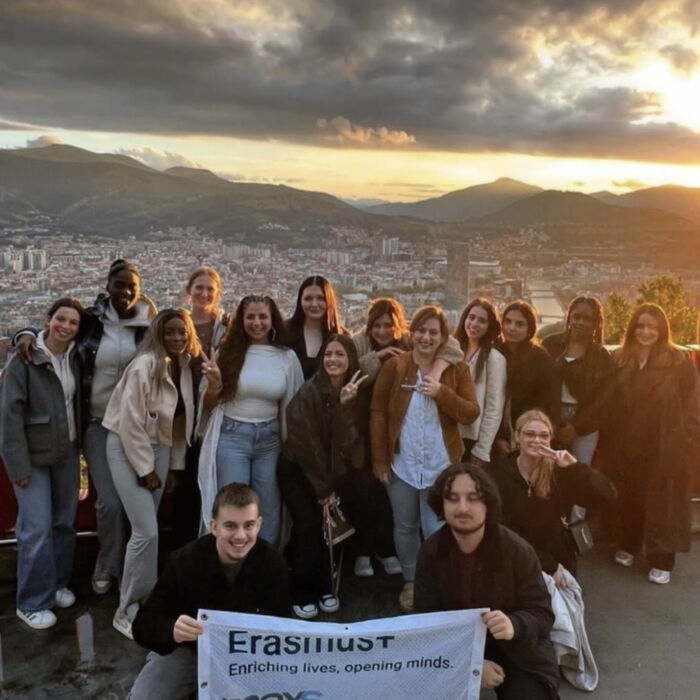 Erasmus Gruppe mit Banner vor einer Stadtkulisse in den Bergen