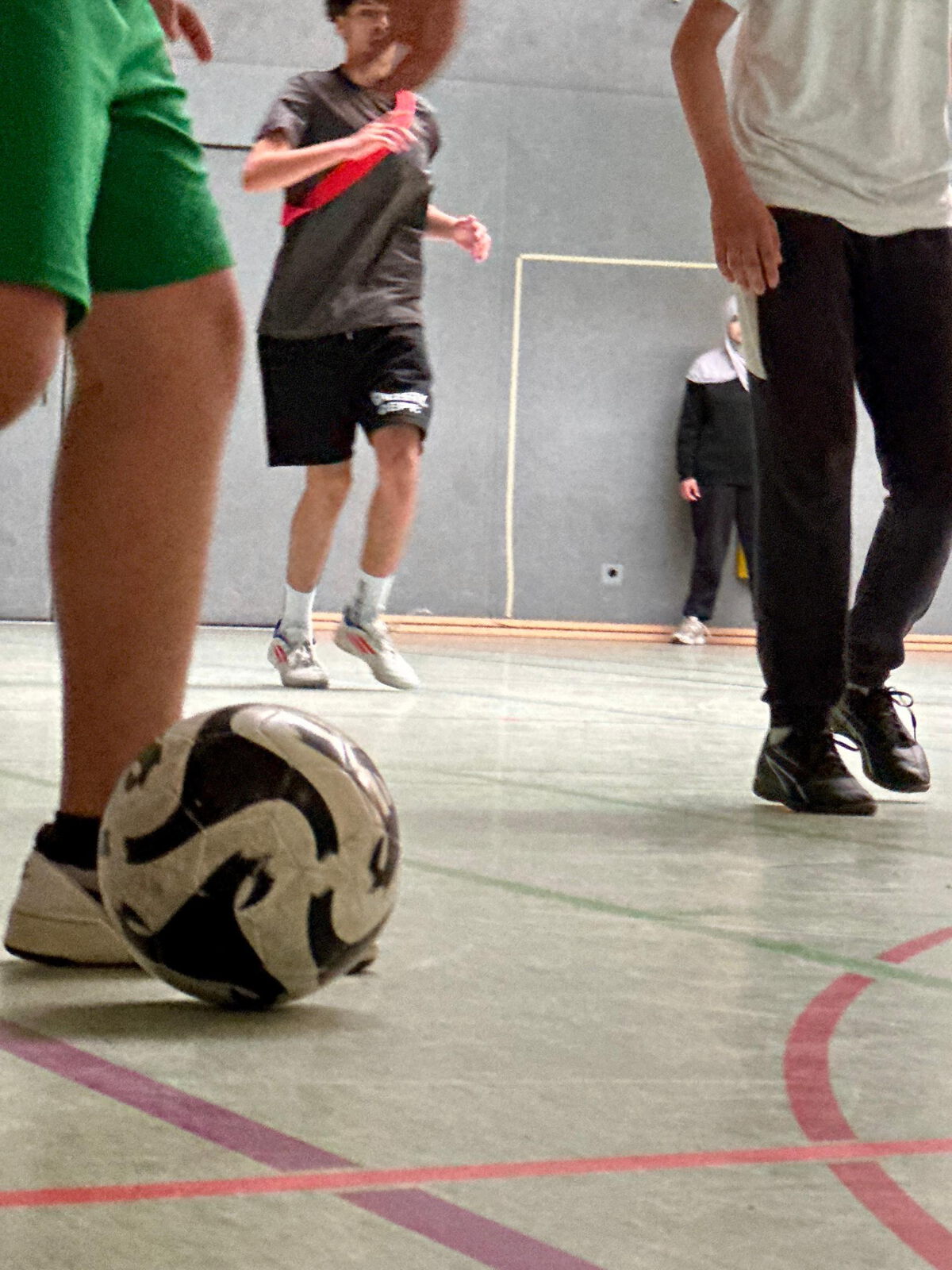 Nahaufnahme eines Fußballs am Fuß eines Spielers in der Sporthalle