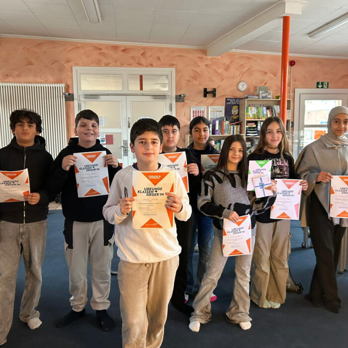 Schülerinnen und Schüler zeigen ihre Urkunden vom Lesewettbewerb