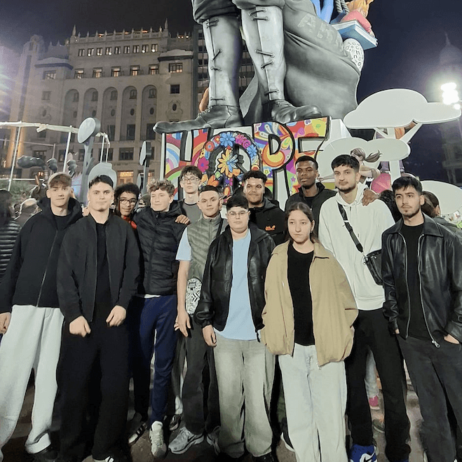 Jugendliche vor einer großen Fallas Figur bei Nacht in Valencia.