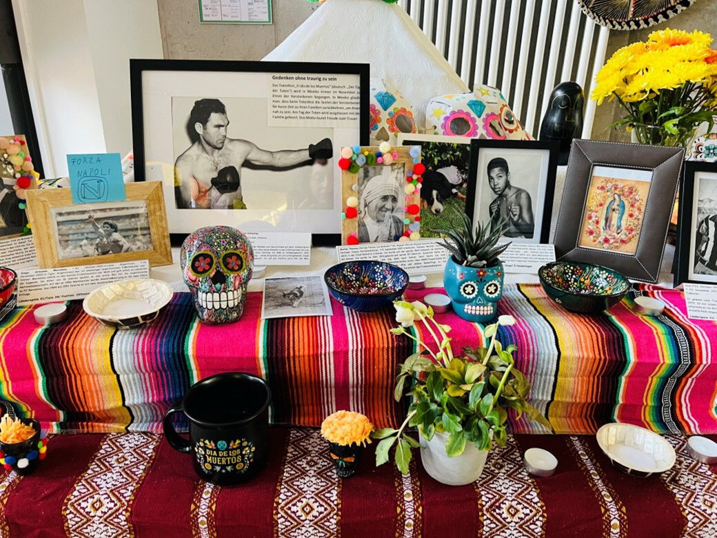Ein farbenfroher Altar mit Fotos, Totenkopfdekorationen, Pflanzen und traditionellen Mustern, gestaltet im Stil des mexikanischen Día de los Muertos