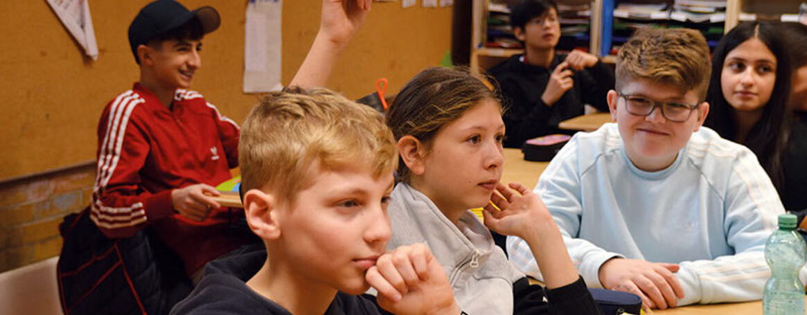 Schülerinnen und Schüler melden sich im Unterricht
